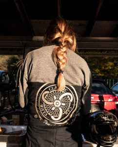 A woman with her back to the camera with a Classic Car Club logo on her sweatshirt
