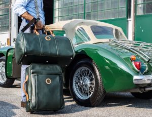 green luggage set next to green classic car