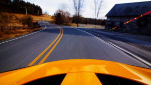 Orange car driving down the road